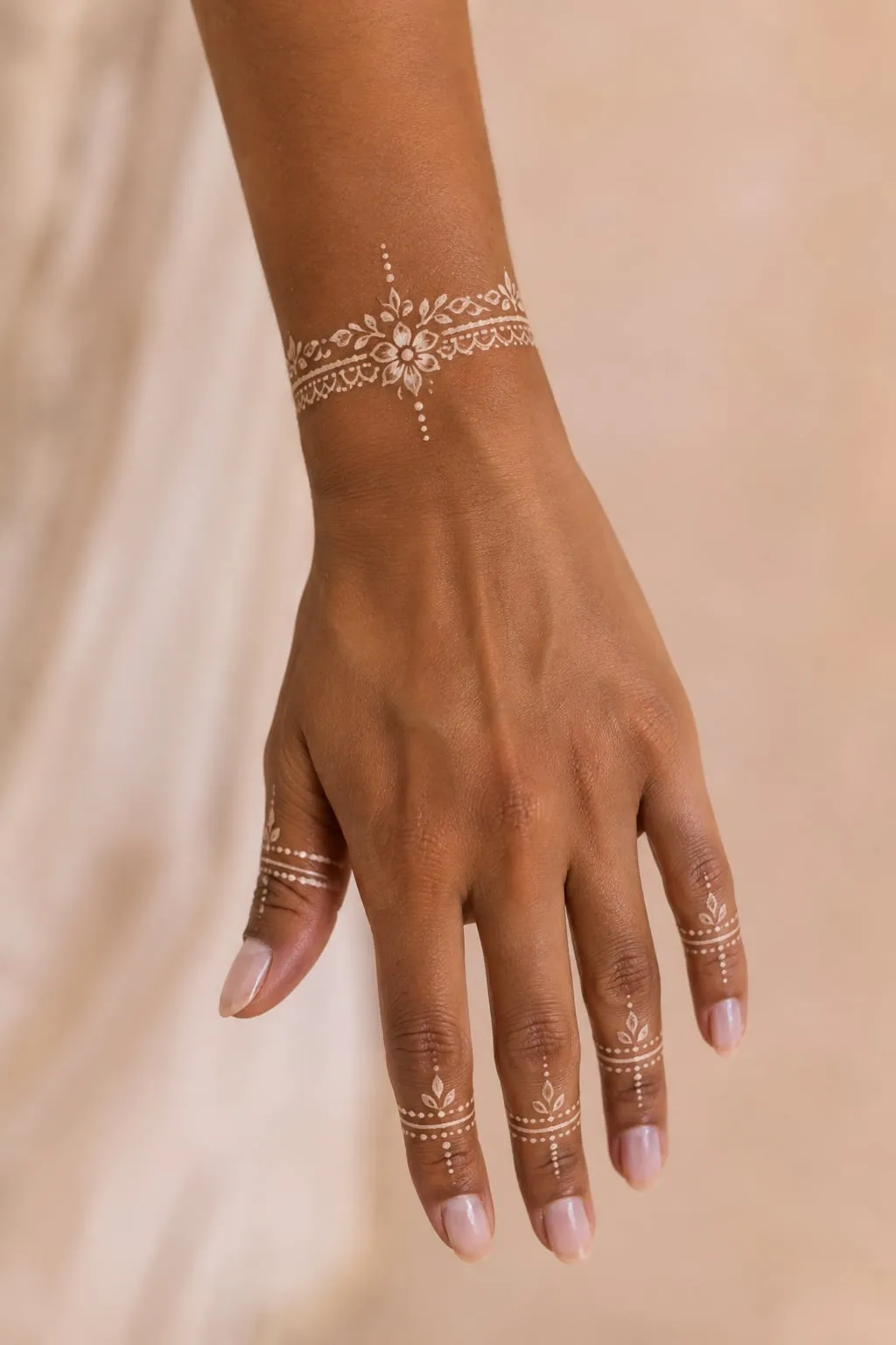 White henna design on the wrist and fingers